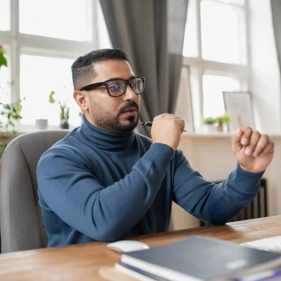contemporary-teacher-sitting-by-workplace-in-front-of-computer-monitor